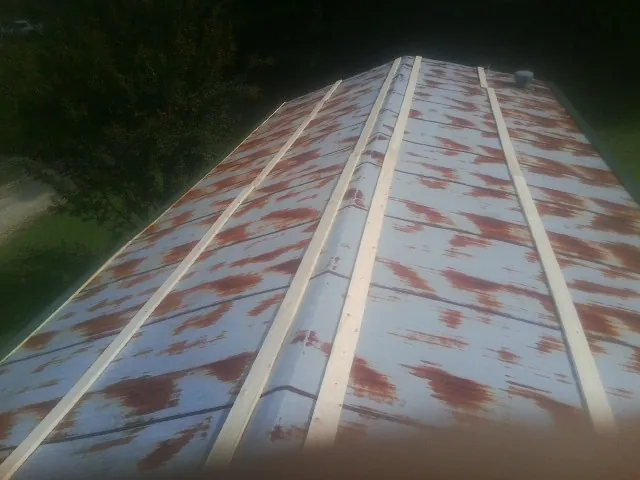 Rusted metal roof panels with new wood purlins before replacement — Storm Damage Roof Repair in Cement by Roofing Brothers