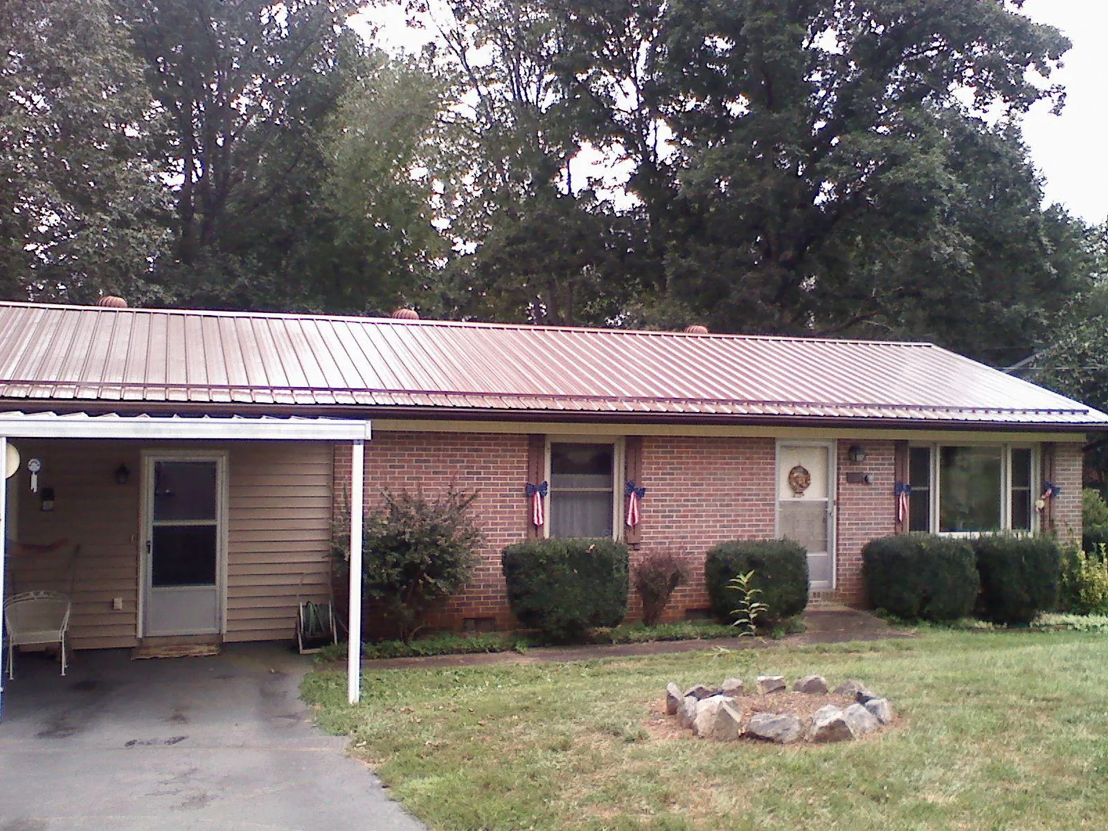 Bronze metal roof and carport on a brick ranch home — Roof Repair work by our crew in Cement